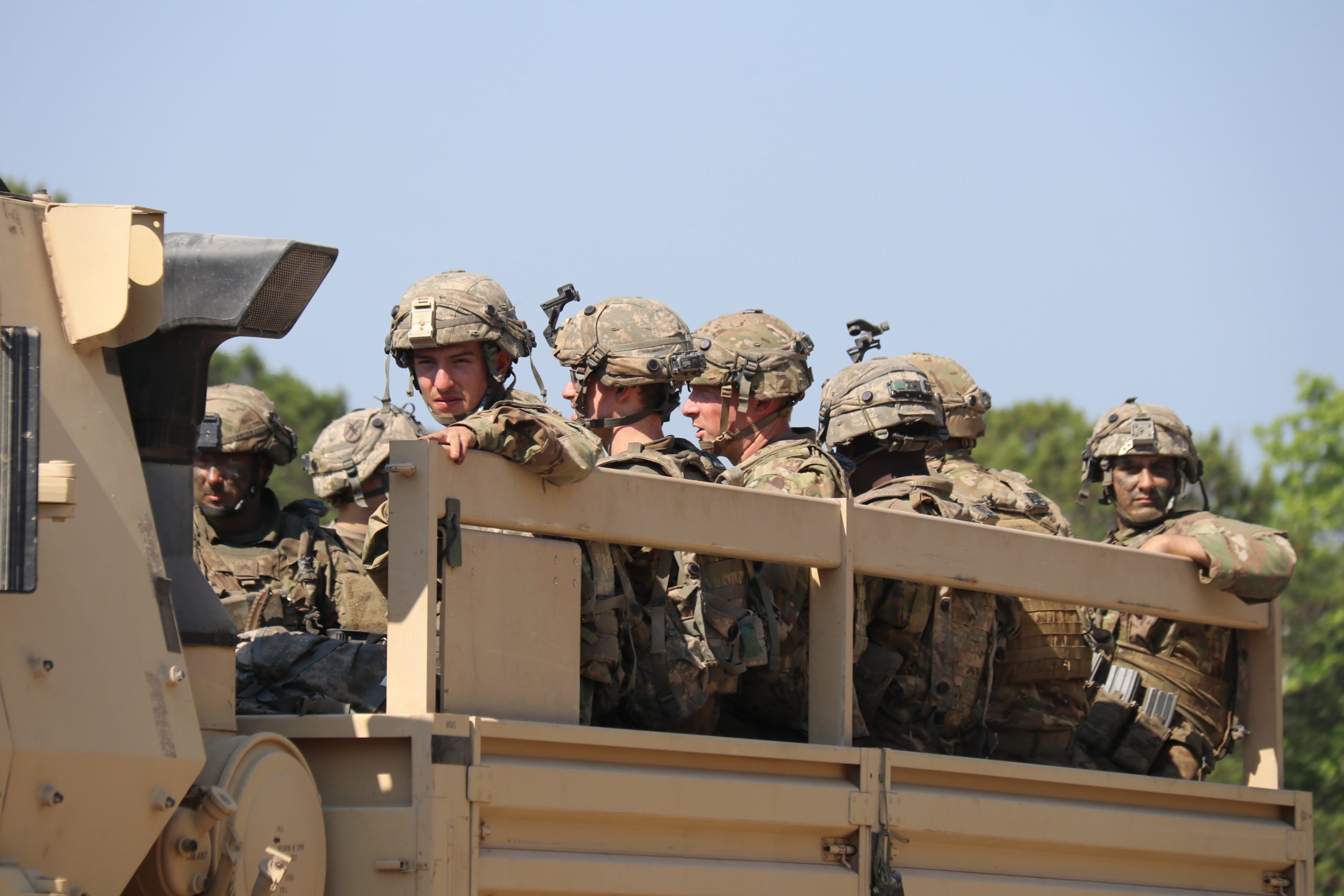 Soldater sitter på lasteplanet i en bil