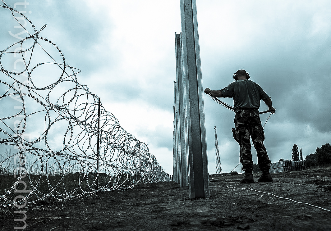 En soldat står ved Ungarns mur langs grensen til Serbia. Muren settes opp i august 2015.
