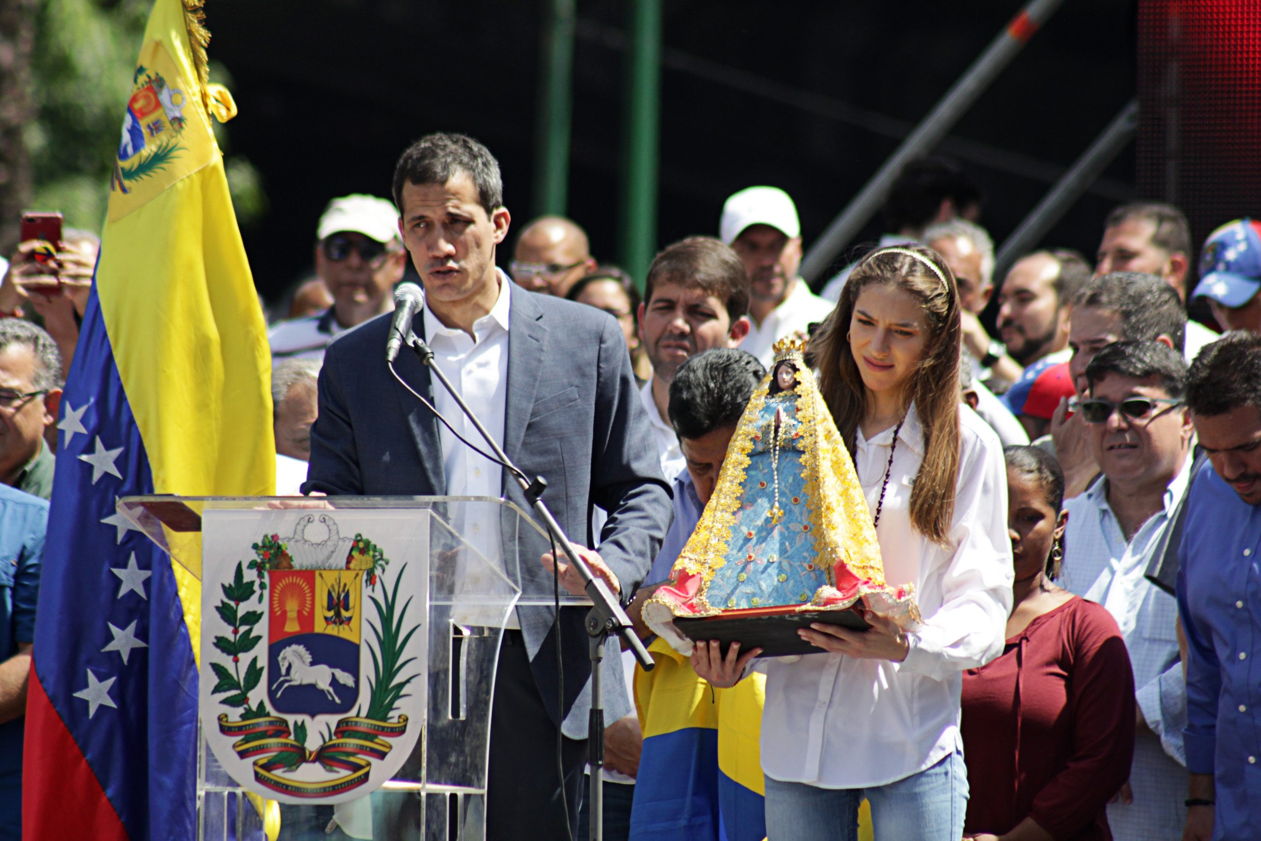 Juan Guaidó snakker fra en talerstol ute. Bak ham står det masse mennesker. 