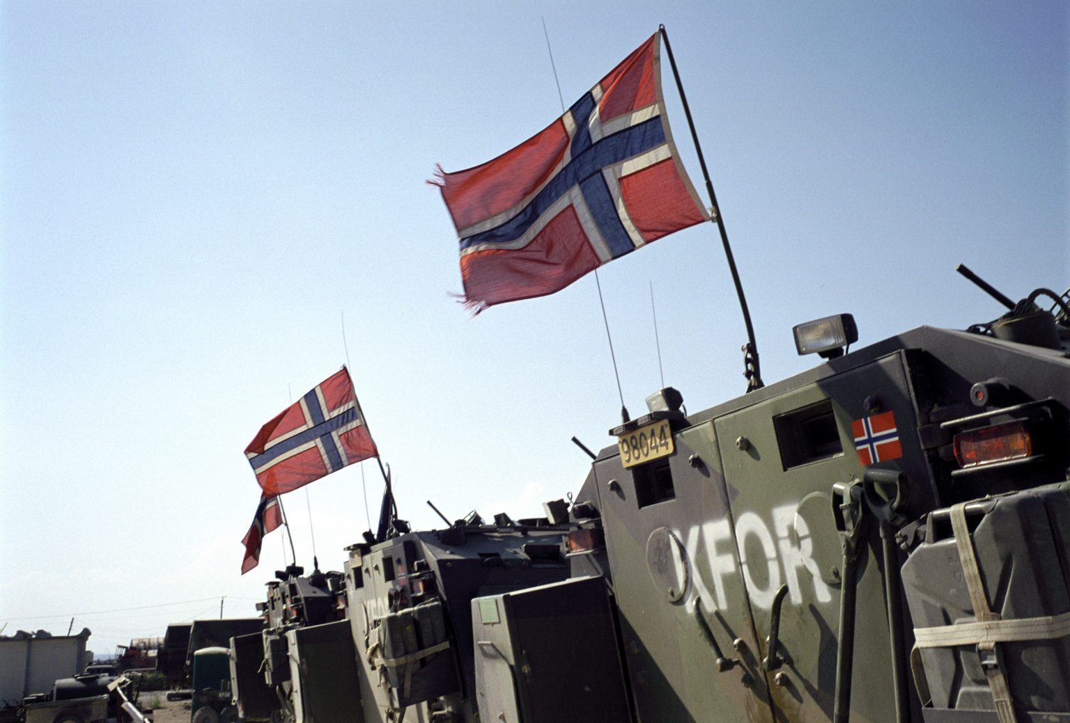 Militære kjøretøy med skriften KFOR og norske flagg på