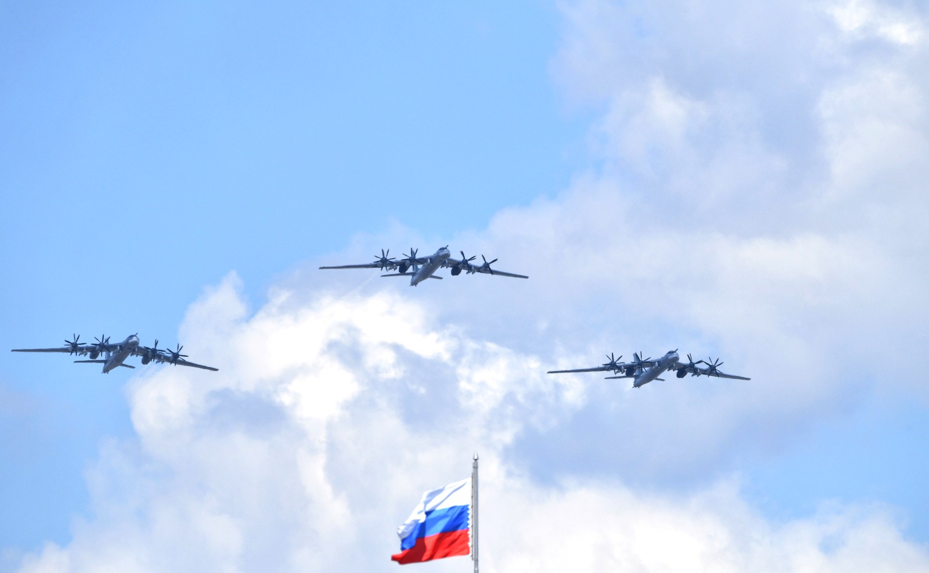Tre militære fly flyr over et russisk flagg