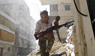 En mann med våpen løper i ruinene av en syrisk by.
