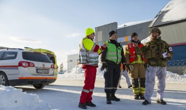 Personell fra ambulanse, politi og forsvaret står sammen ute i snøen