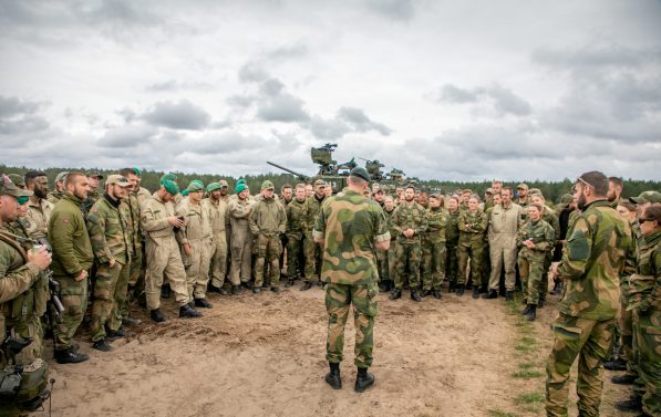 Et titalls soldater står i en halvmåne rundt Sjef for Hæren, alle i uniform