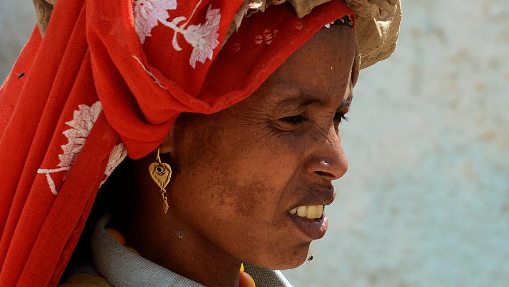 Etiopisk kvinne med rødt slør over håret