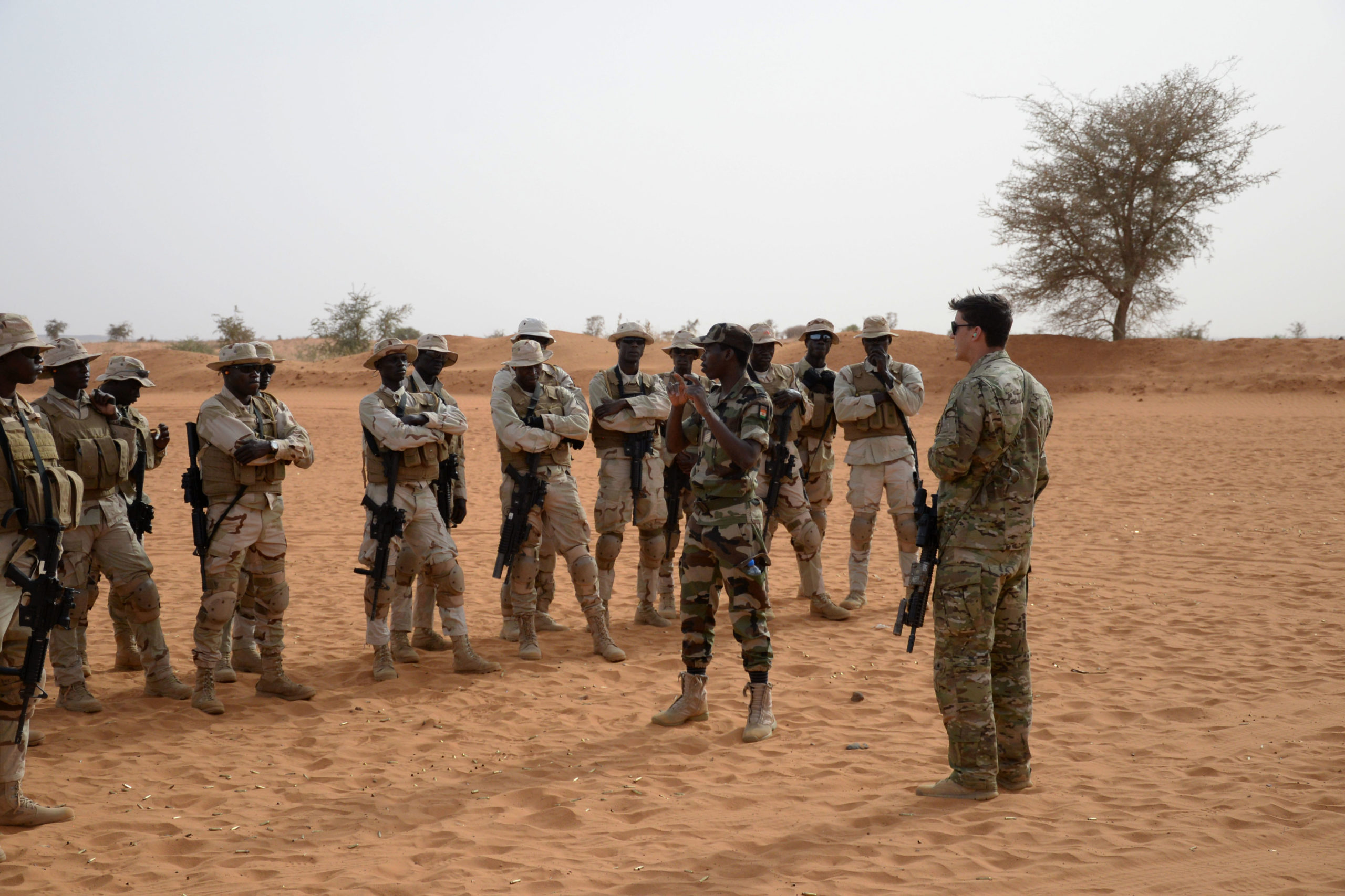 Soldater blir forklart våpenbruk, ørkenlandskap rundt