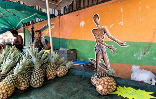 mann på marked, selger ananas