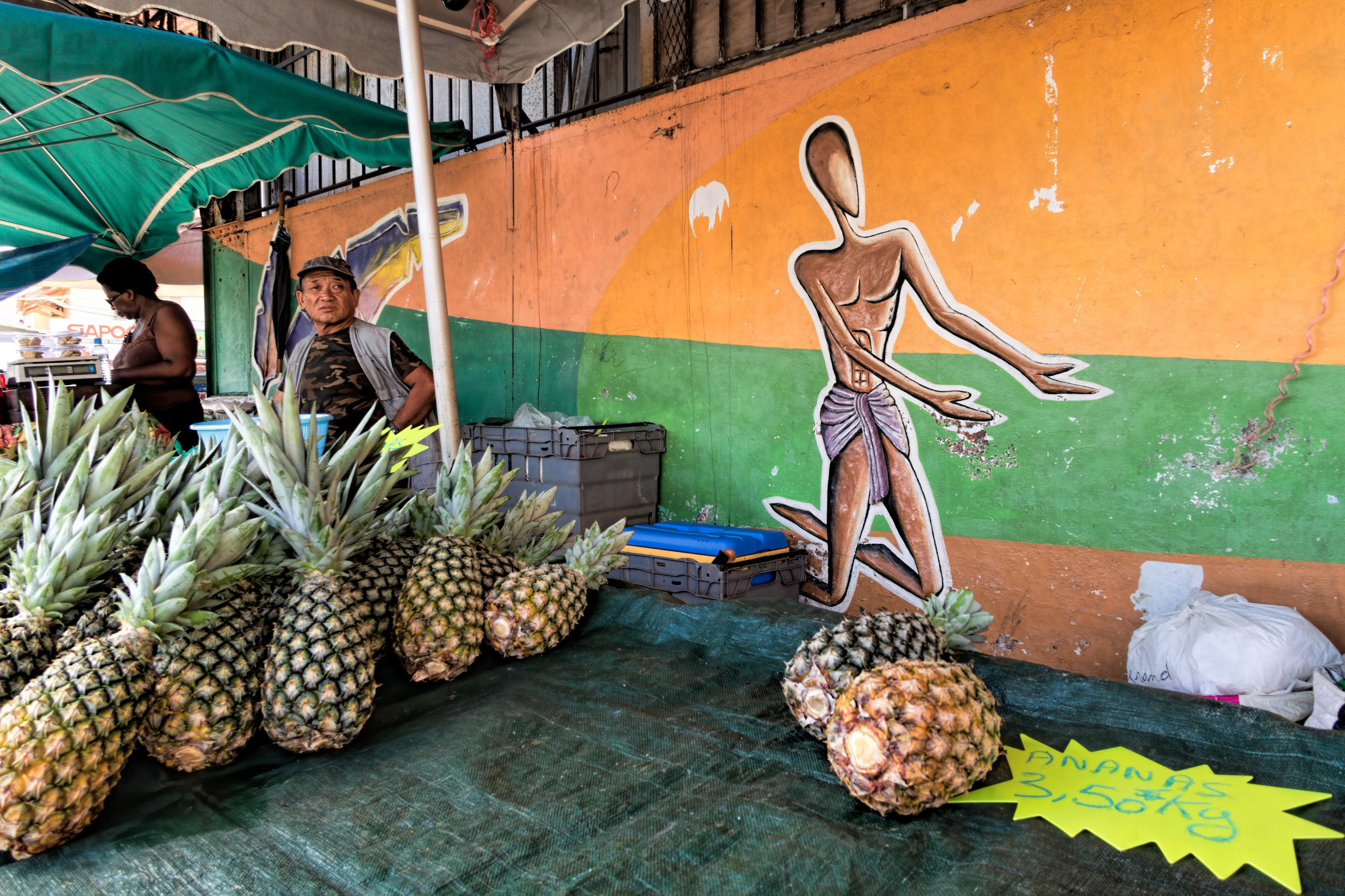 mann på marked, selger ananas 