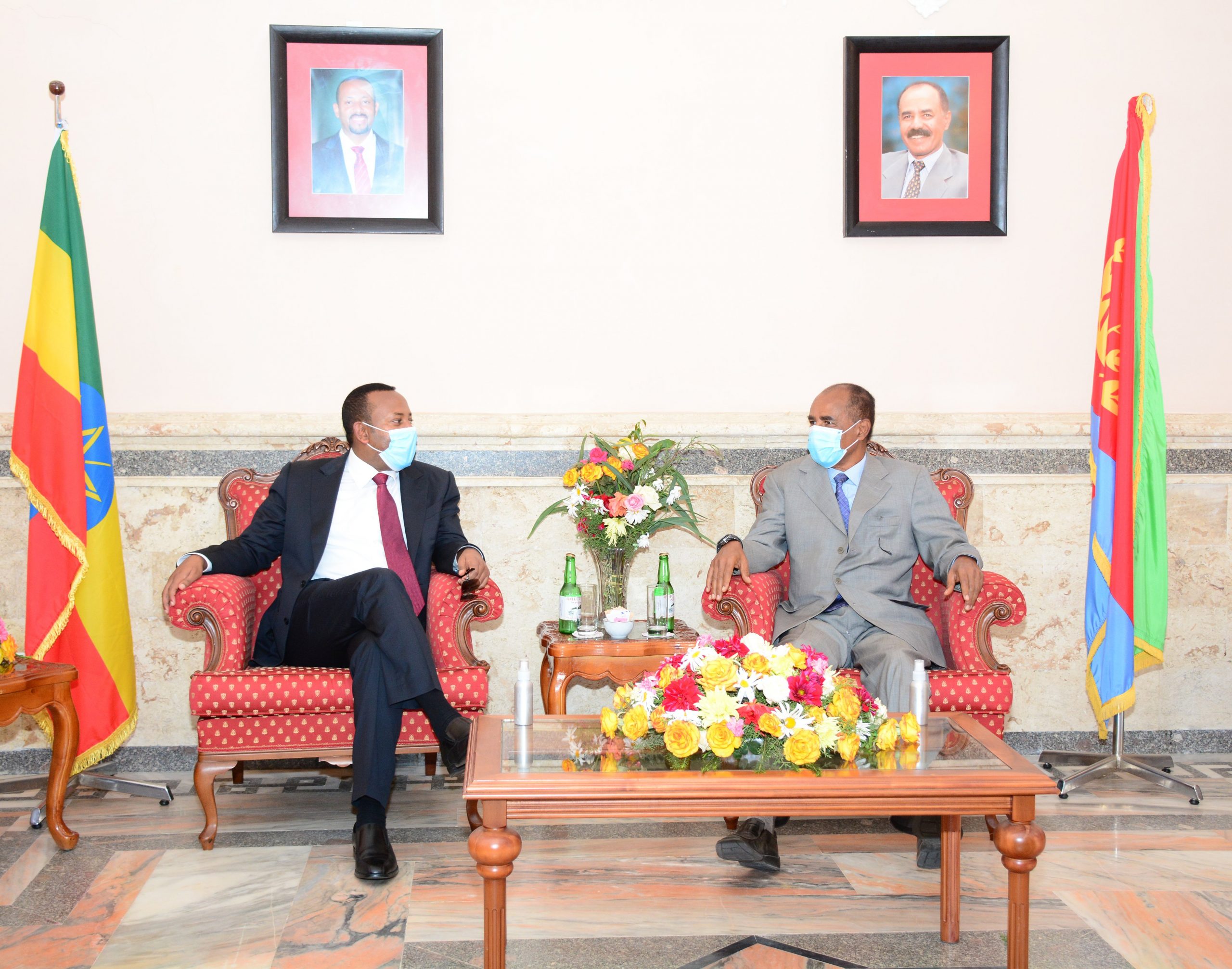 Statslederne fra Etiopia og Eritrea sitter i hver sin røde lenestol. De har på dress og munnbind, og på hver sin side har de flagg fra landet de representerer.