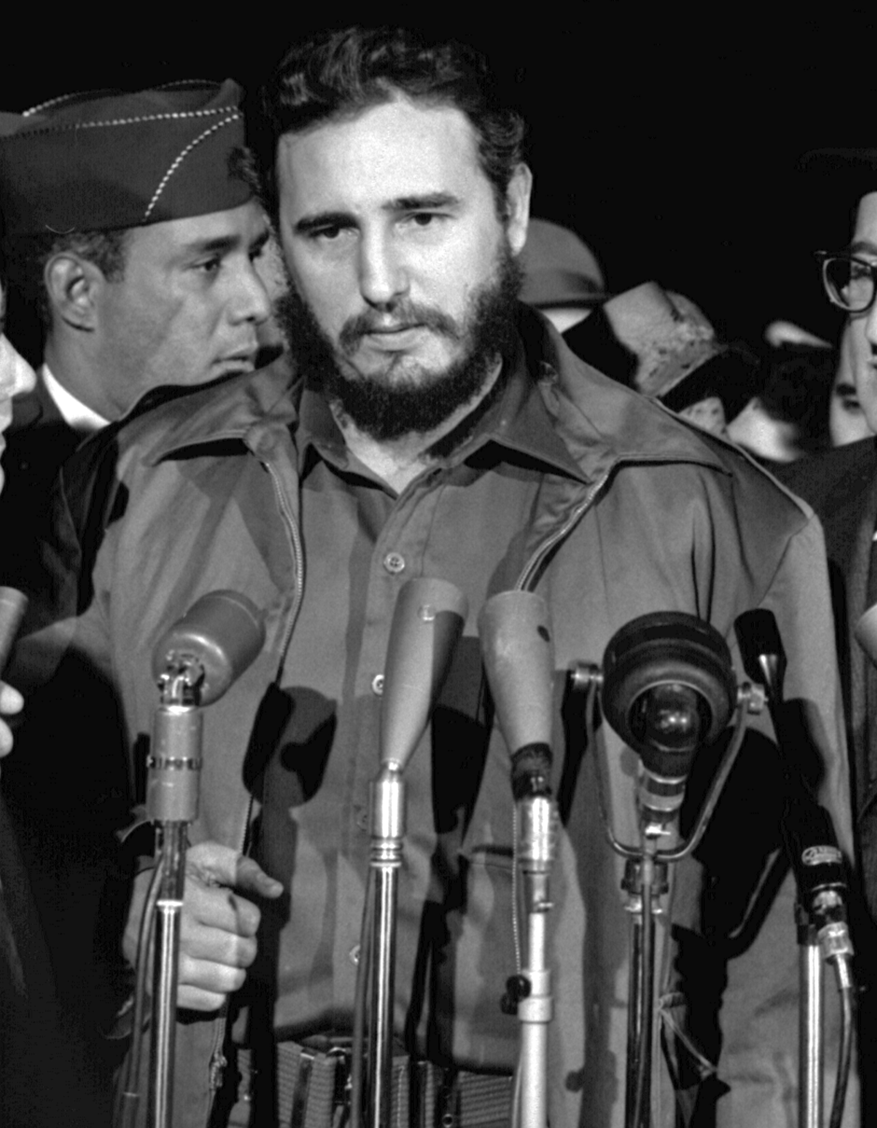 Portrett av Fidel Castro. Han står foran et mikrofonstativ