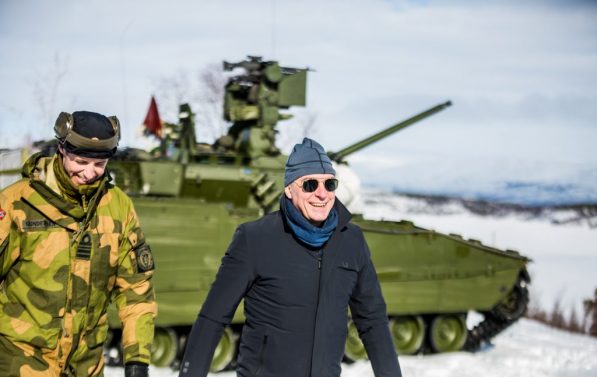 Forsvarsminister Frank Bakke Jensen går foran et helikopter med solbriller på