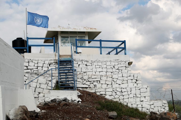 Bilde av en vaktpost med FN-flagget veivende utenfor