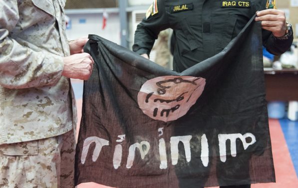 Irakisk soldat overrekker IS-flagg til amerikansk general.