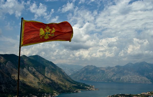 Montenegros flagg veiver i vinden, med Kotor Bay i bakgrunnen.