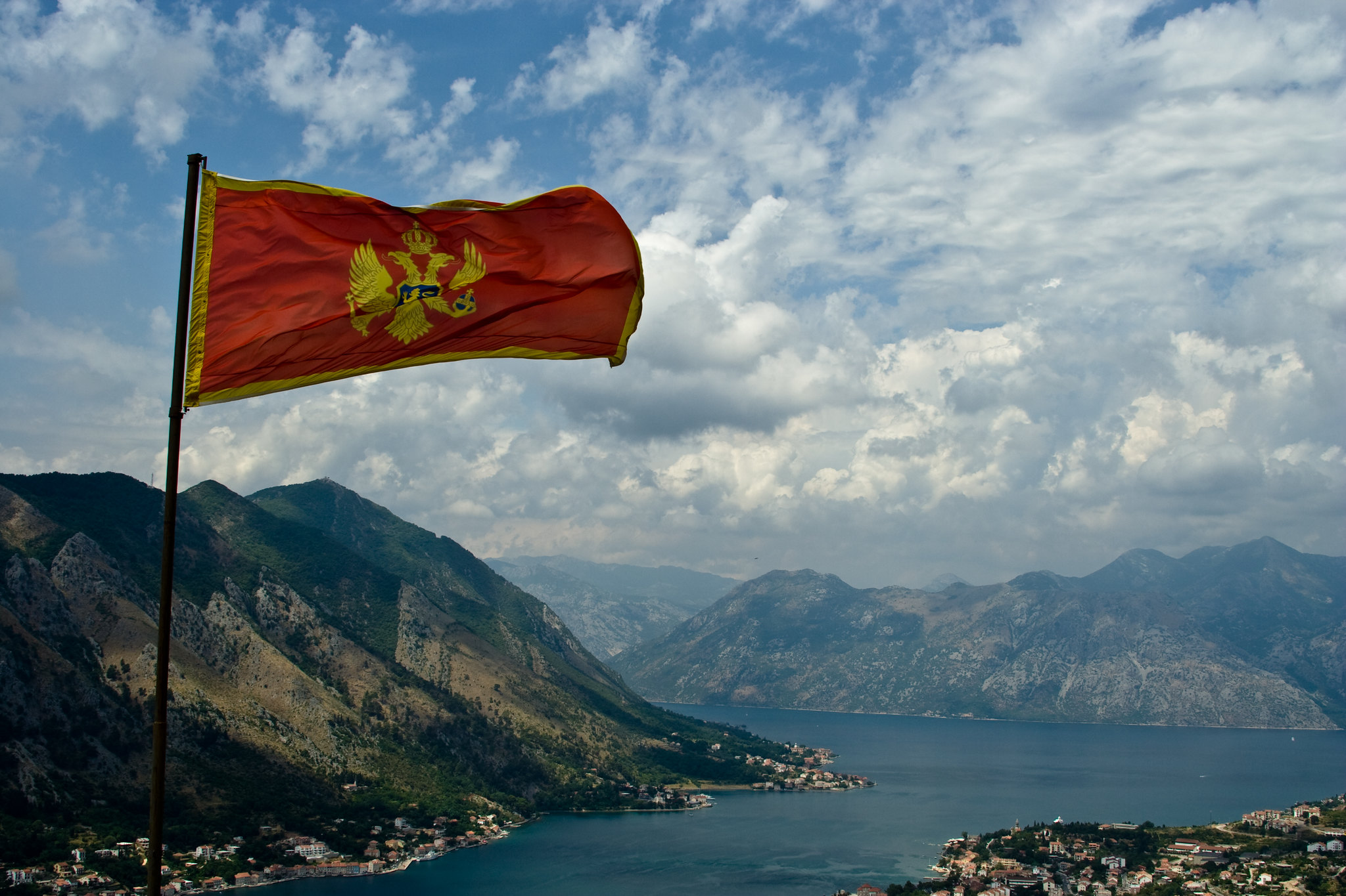 Montenegros flagg veiver i vinden, med Kotor Bay i bakgrunnen.