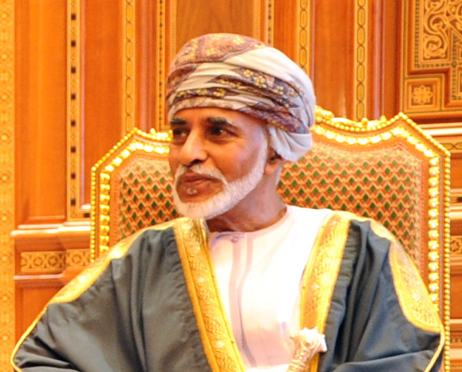 Sultan Qaboos sitter i en stol og ser mot siden