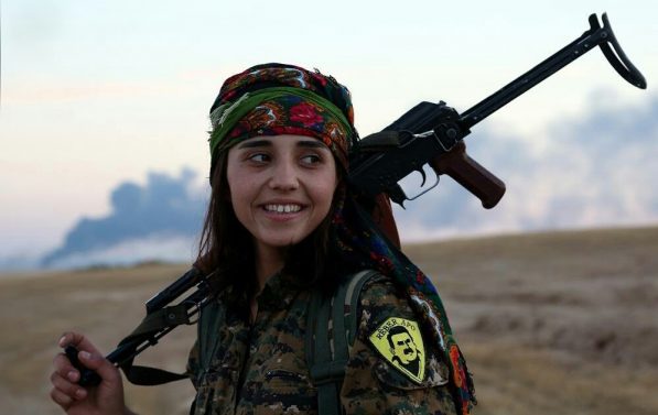 En ung kvinne kledd i militæruniform med en rifle over skulderen.