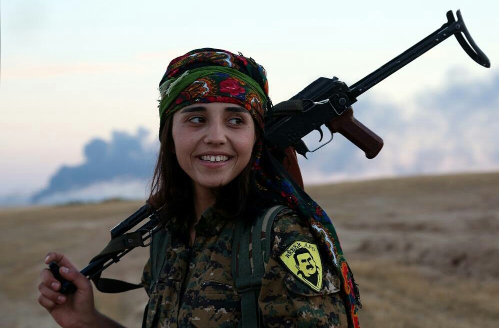 En ung kvinne kledd i militæruniform med en rifle over skulderen.