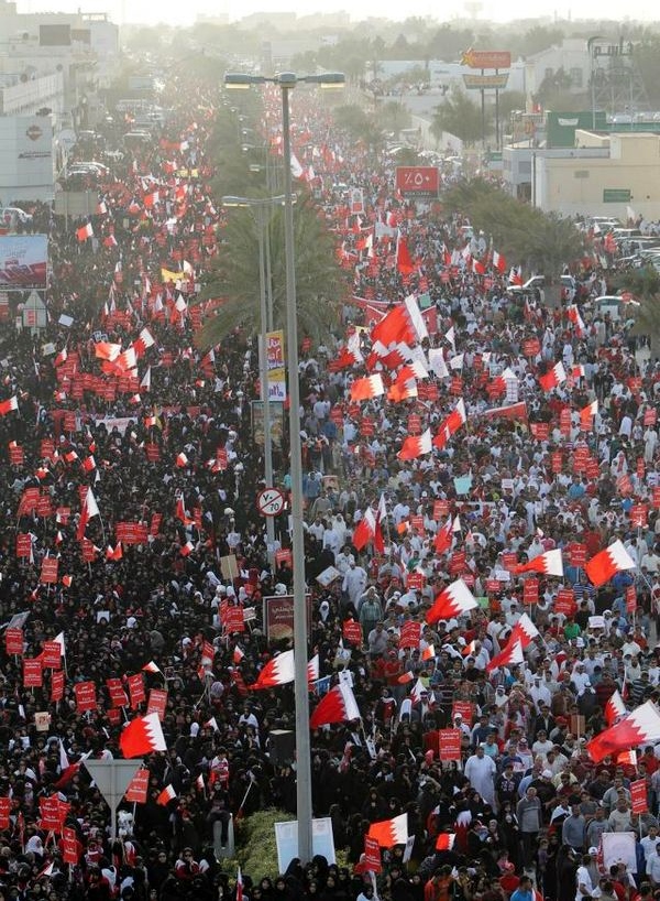 Demonstranter med bahrainske flagg dekker en stor gate.