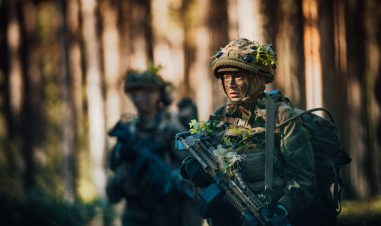 Kvinnelig soldat går gjennom skogen.