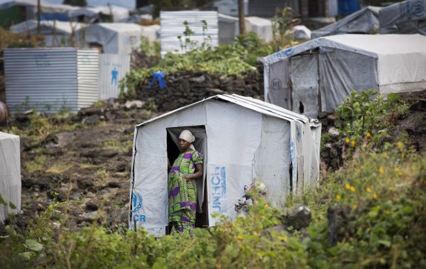 En kvinne står i døråpning til et telt fra FN.