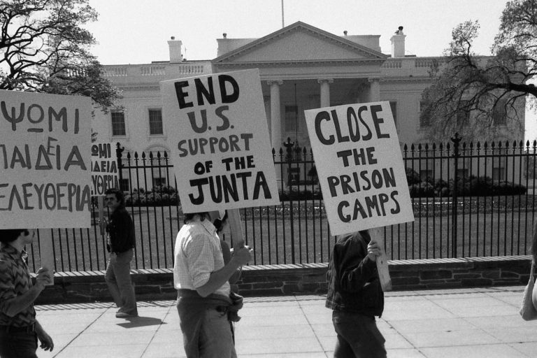 Demonstranter foran det hvite hus med plakater der det bl.a. står "end U.S. support of the Junta".