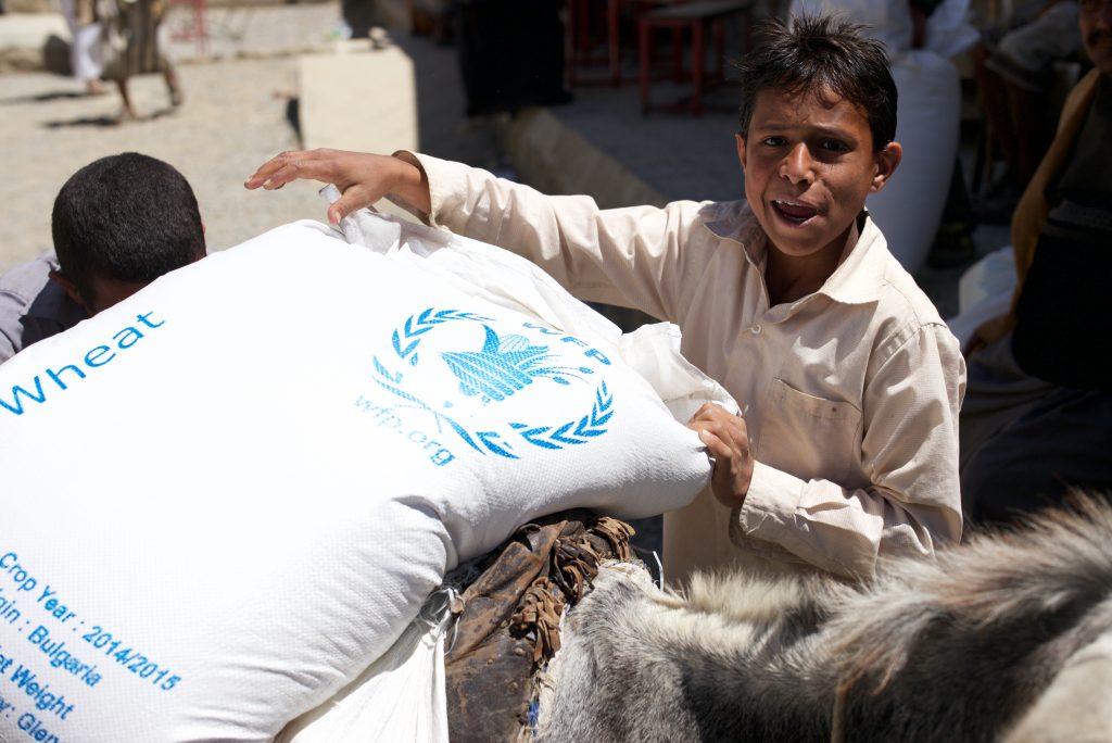 En gutt tar i mot en sekk med mat fra FNs matvareprogram