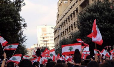 Folkemengde i en gate veiver med de libanesiske flagget