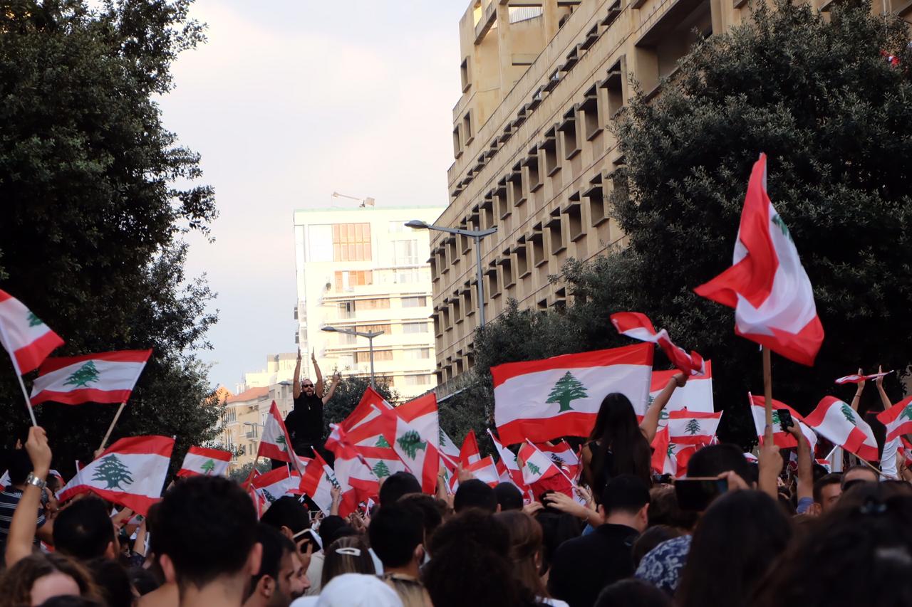 Folkemengde i en gate veiver med de libanesiske flagget