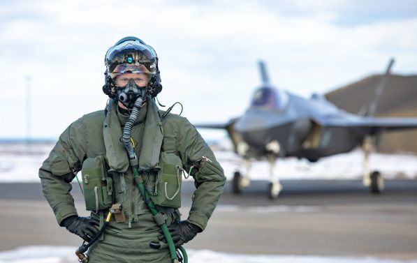 Pilot poserer foran et jagerfly