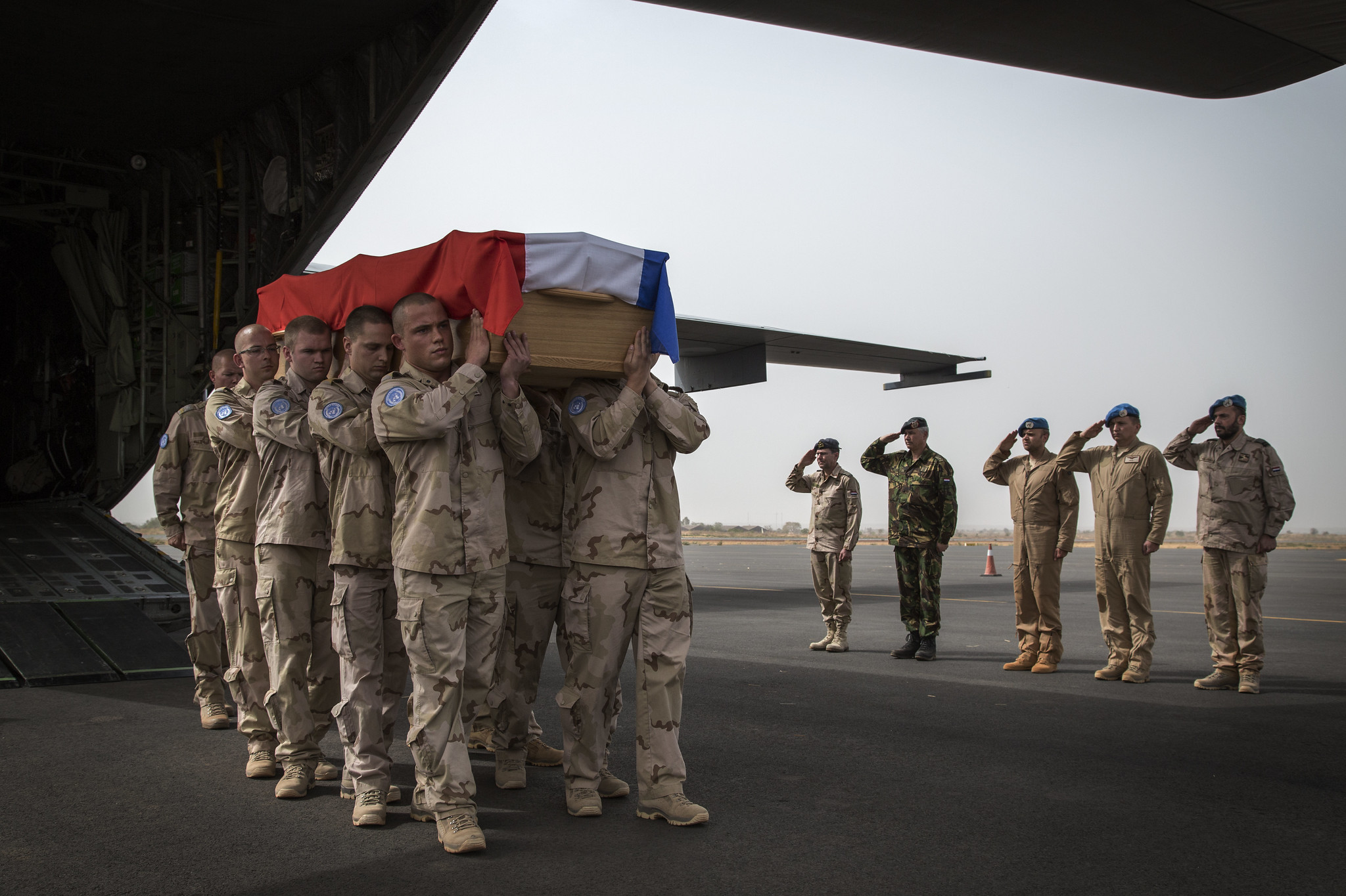 Soldater bærer en kiste med det nederlandske flagget over