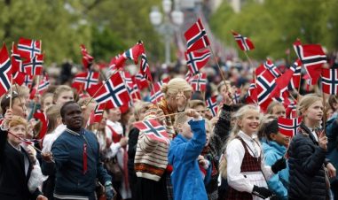 Barn går i tog med norske flagg.