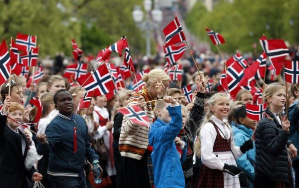 Barn går i tog med norske flagg.