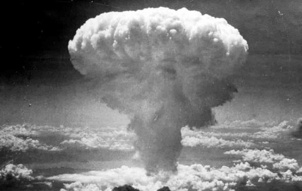 Den karakteristiske "sopp" formen på atombombe ses over skyene i et svart-hvitt bilde