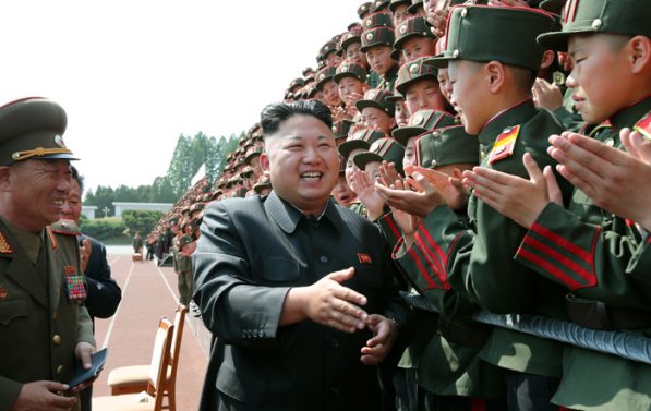 Nord-Koreas statsleder Kim Jong-un møter elever ved en nord-koreansk skole. Kim smiler.