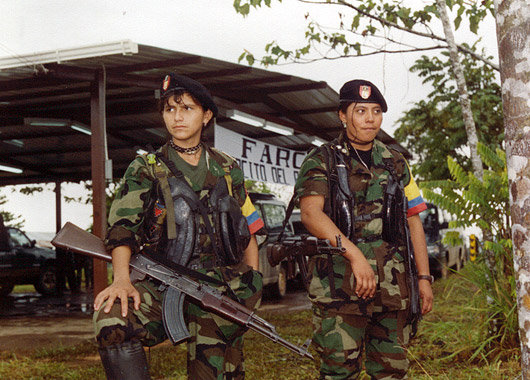 To unge kvinner i militæruniform og våpen