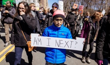 En gutt går med et skilt i en demonstrasjon hvor det står "Am I Next?"