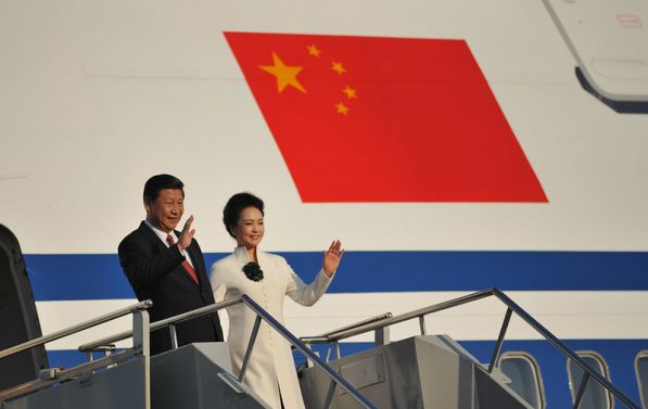 Kinas president Xi Jinping vinker utenfor flyet sitt.