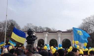 Masse folk står tett i tett, det er ukrainske flagg og ballonger i gult og blått