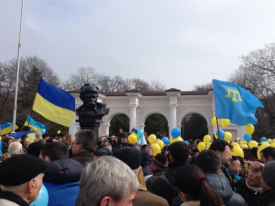 Masse folk står tett i tett, det er ukrainske flagg og ballonger i gult og blått