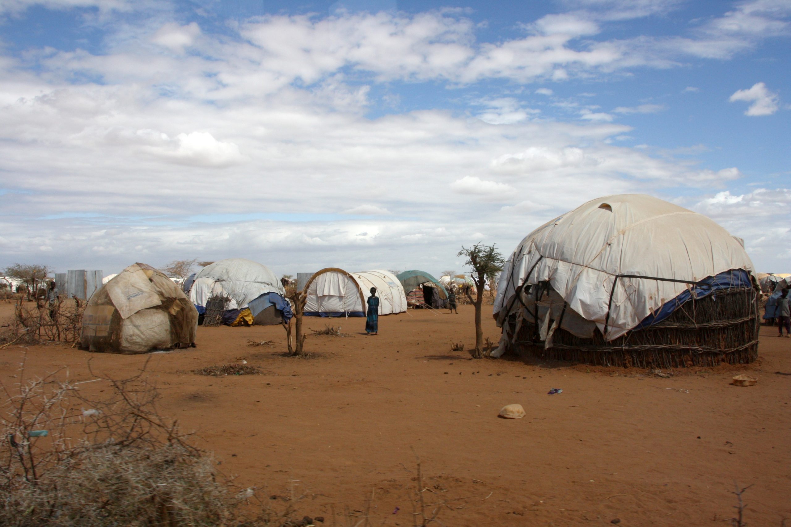 Flere telt står plassert på et tørt område.