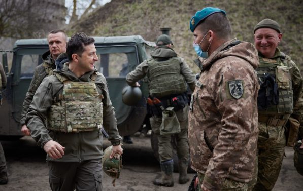 President Volodomyr Zelenskij mæter soldater i Donbass, bil i bakgrunnen.