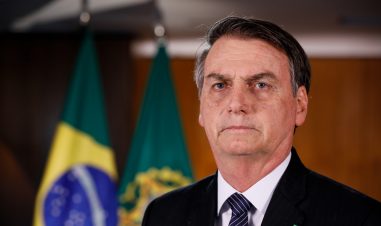 Nærbilde av Bolsonaro med det brasilianske flagget i bakgrunnen
