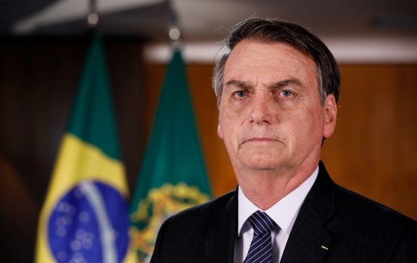 Nærbilde av Bolsonaro med det brasilianske flagget i bakgrunnen