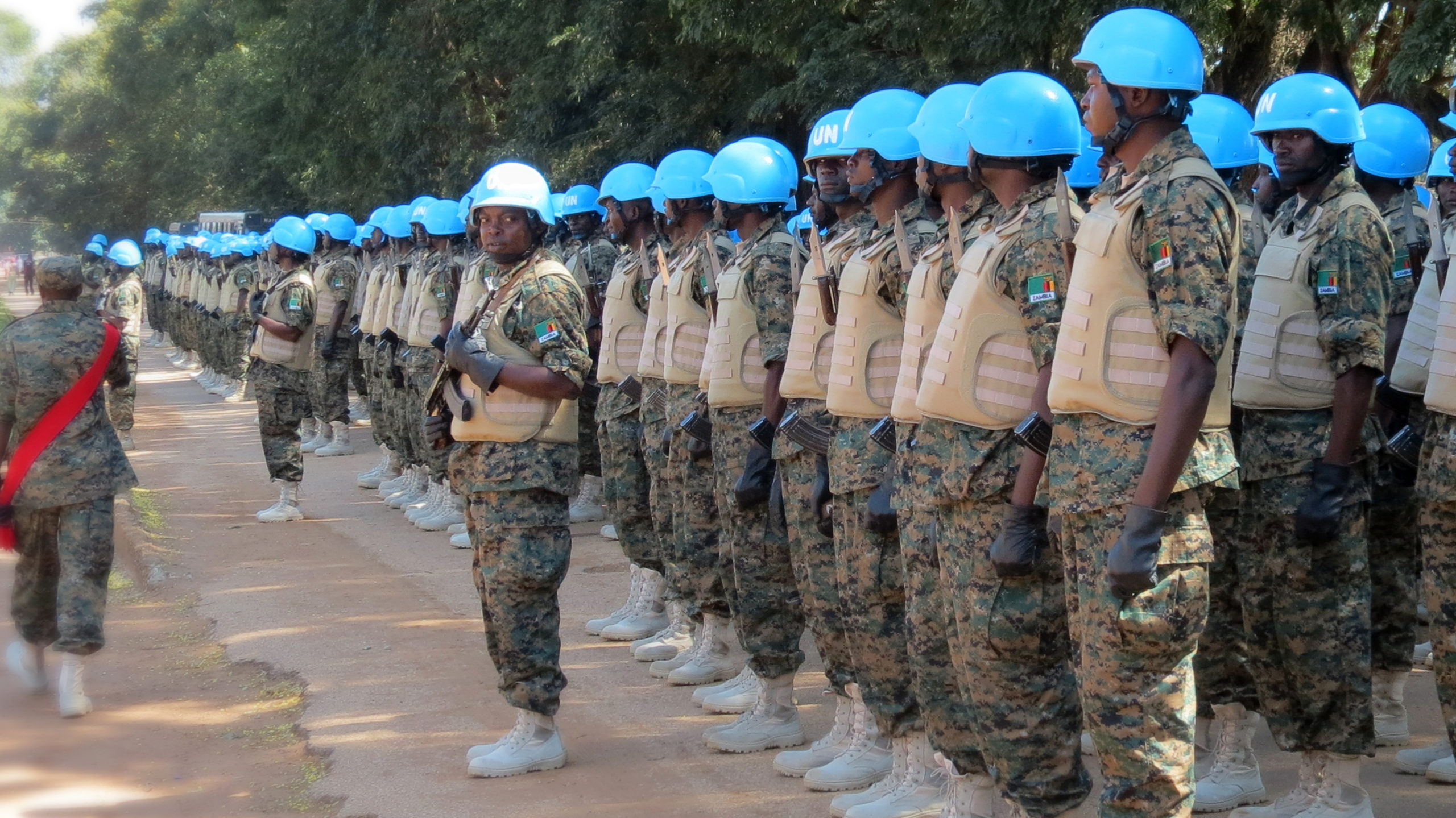 FN-soldater, ikledd blå hjelmer, står på rekke og rad for inspeksjon og prøving av nye uniformer.
