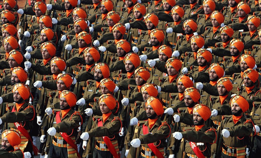 Indiske soldater på rekke og rad kledd i karakteristiske farger - brun uniform, oransje turban.