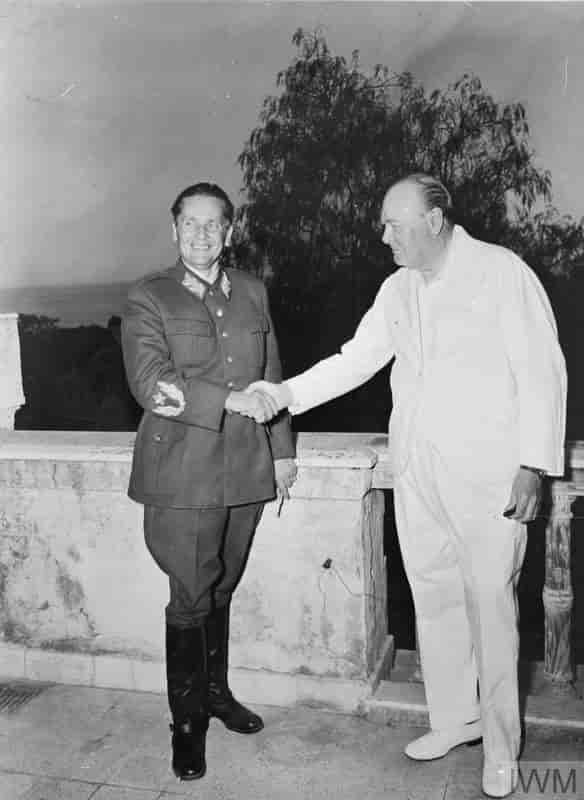 Tito kledd i uniform og Churchill kledd i hvit dress håndhilser.