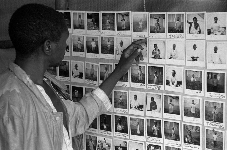 En mann ser på rekken av bilder hengt opp på en vegg