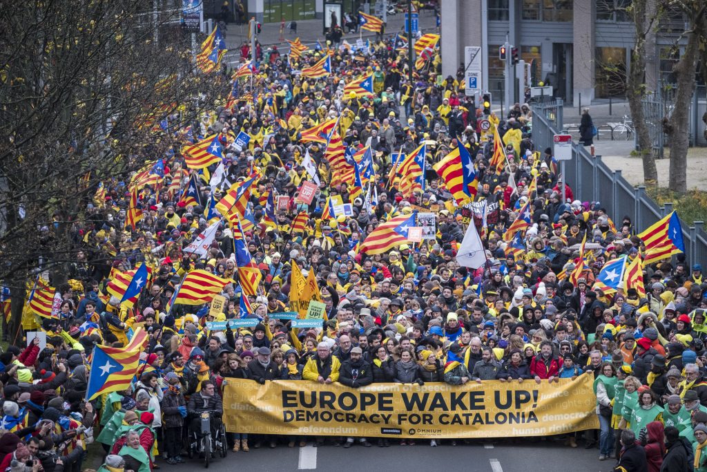Masse demonstranter veiver med det katalanske flagget. Forrest i opptoget ser man banneren "Europe wake up. Democracy for Catalonia!".