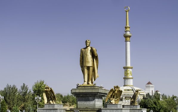 En gullstatue av en dresskledd mann